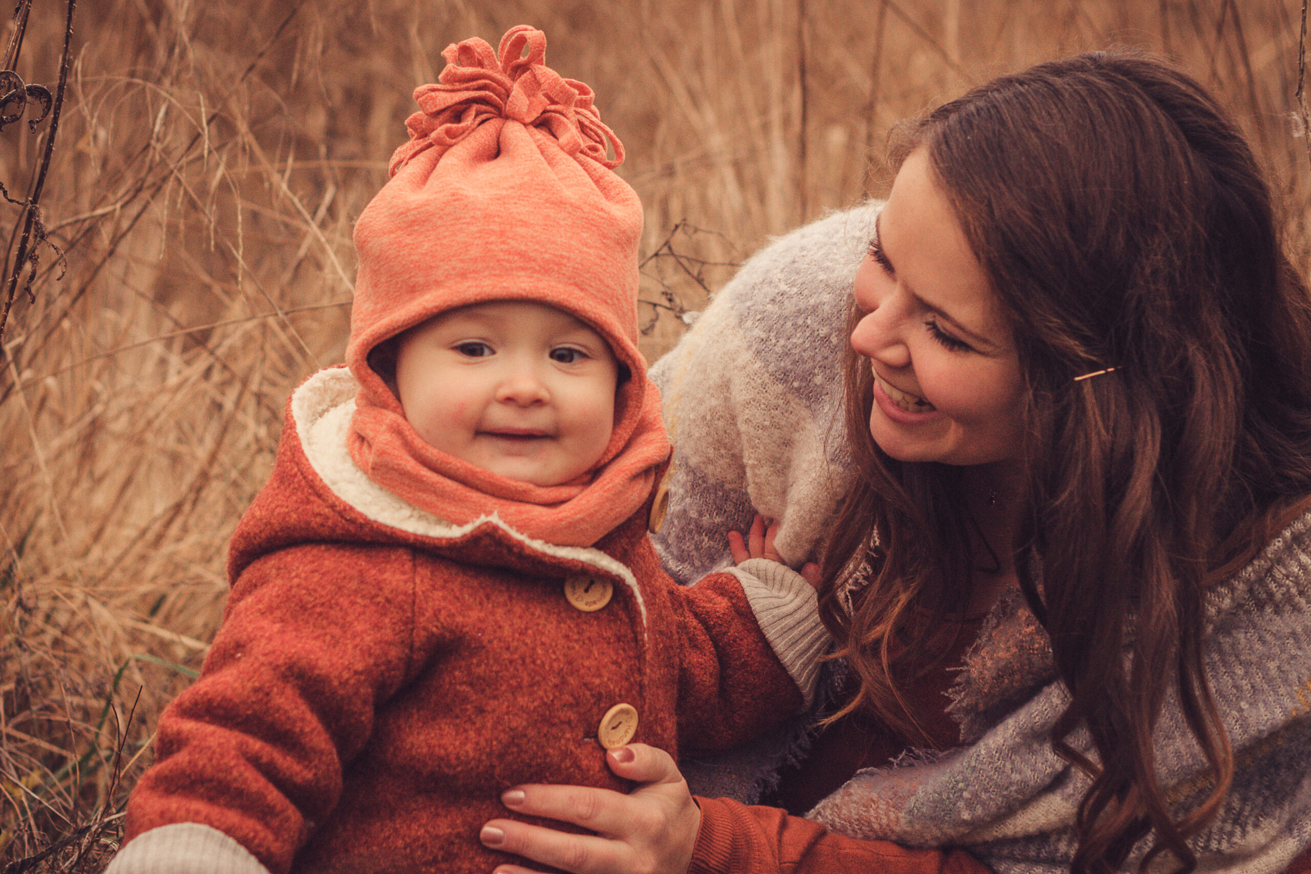 Mutter mit Kind im Feld sitzend familienshooting outdoor familienshooting familienshootings