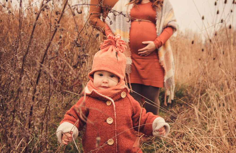 Kind im Vordergrund laufend, im Hintergrund die Eltern familienshooting outdoor familienshooting familienshootings