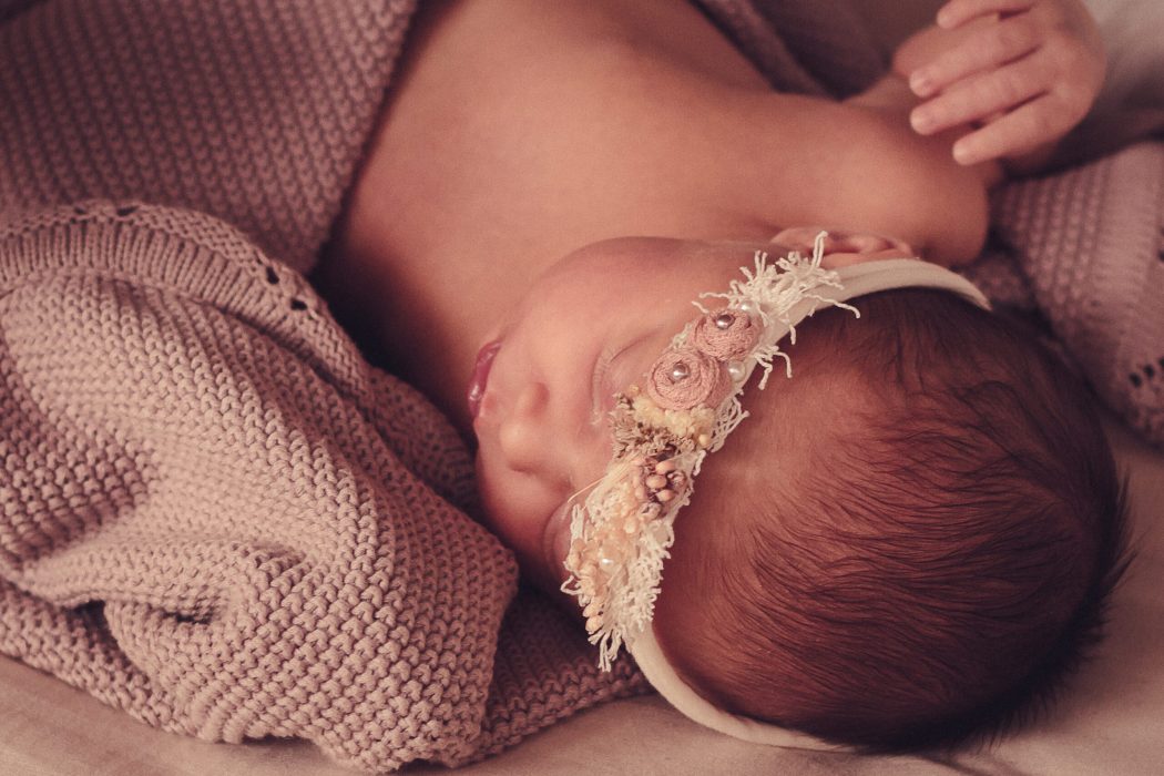 Neugeborenes mit Stirnband auf Decke newborn fotoshooting newborn shooting new born fotoshooting
